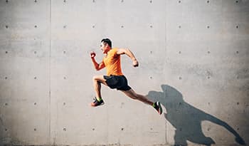 Fit healthy Asian man in orange shirt running