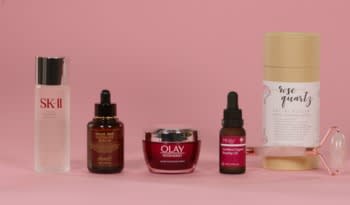 five skincare and self-care items of different shapes and sizes in a row against a pink background