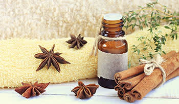 Cinnamon essential oil with towel and cinnamon cloves
