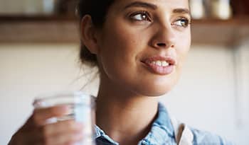 Close up of young woman with glass of water