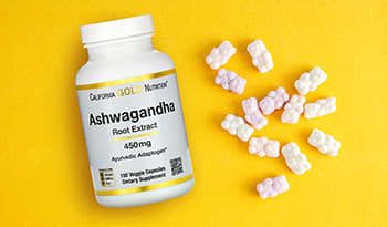 Ashwagandha supplement bottle and gummies on yellow background