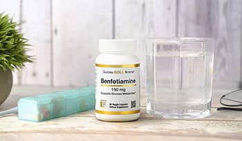 Benfotiamine supplement on table with water glass