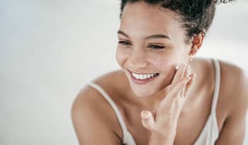woman applying beta glucan moisturizer to her face