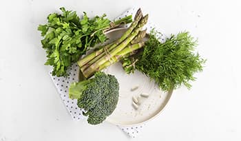 Green vegetables on plate with betaine HCL supplements