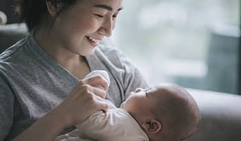 Asian mother holding her baby smiling