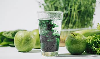 chlorophyll water in clear glass with green fruits and vegetables