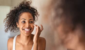 woman applying skincare products for her skin type to her face