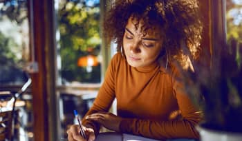 woman writing in her journal practicing self-care