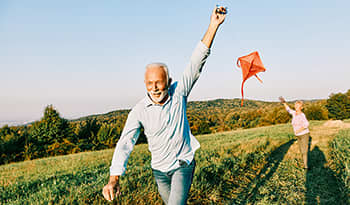 Mature man flying a kite in a field
