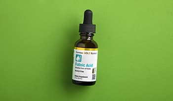 Folic acid supplement on green background