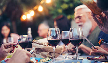 Glasses of red wine on table outdoors