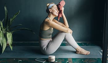 Woman taking a break after working out wiping sweat with towel