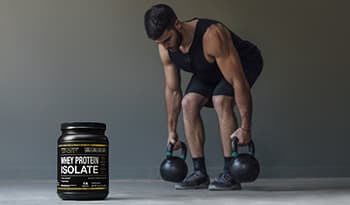 Male athlete exercising with kettlebells with whey protein 