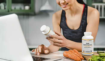 Women examining supplement bottle with healthy food and multivitamin on the table