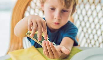 Young boy cleaning his hands with hand sanitizer 