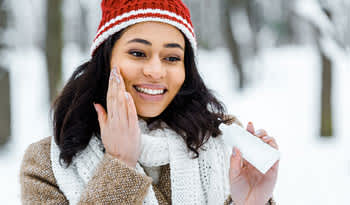woman applying nourishing winter skincare to her face