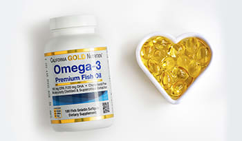 Omega-3 fish oil supplements in heart container on white background