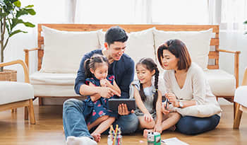 Happy Asian family learning from home with iPad tablet