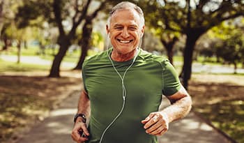 Healthy senior man in fitness wear running in a park