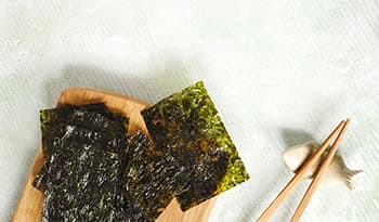 Roasted seaweed snack on wood block with chopsticks 