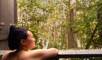 woman participating in self-care in outdoor forest hot spring