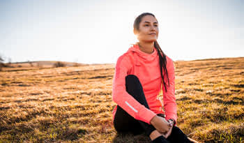 woman sitting in a field by herself practicing self-care mantras