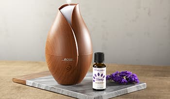 Essential oil diffuser on table with lavender oil for sleep