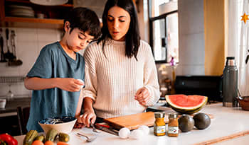 Mother and son cooking in the kitchen with healthy food and spices