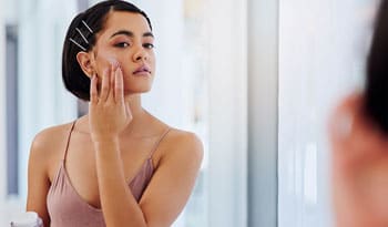 woman applying lightweight summer moisturizer to her skin