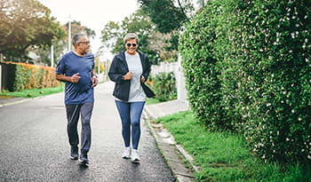 Mature man and woman jogging outside