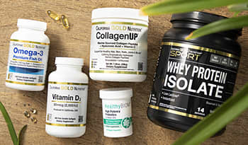 Flat lay of supplements on table with palm plant including omega-3 fish oil, vitamin D, collagen, pr