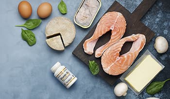 Vitamin D foods like eggs, spinach, salmon, sardines, and supplement bottle