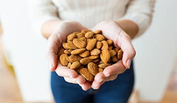 Young woman holding almonds in her hands