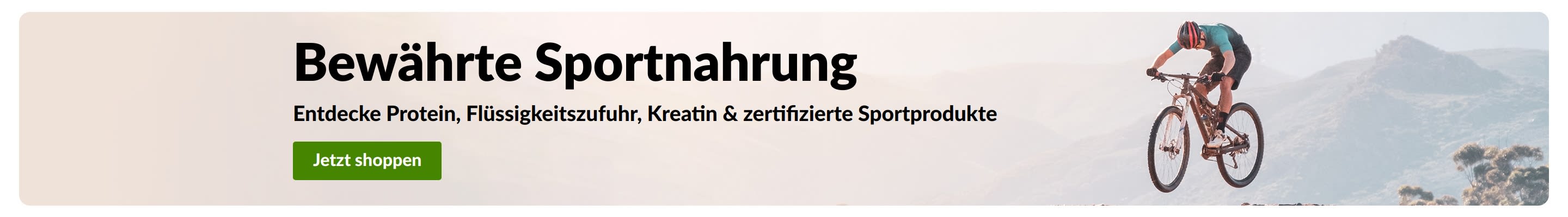 „Bewährte Sportnahrung“-Banner mit einem Mountainbiker und einem „Jetzt shoppen“-Button für Protein, Flüssigkeitszufuhr, Kreatin und sportzertifizierte Produkte.