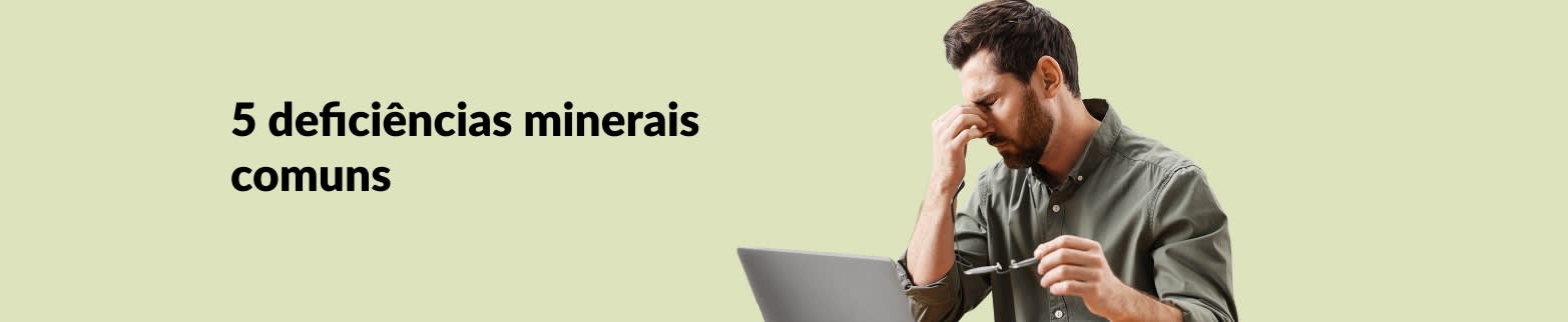 Banner para artigo sobre 5 deficiências minerais comuns, apresentando um homem cansado segurando óculos em frente a um laptop.