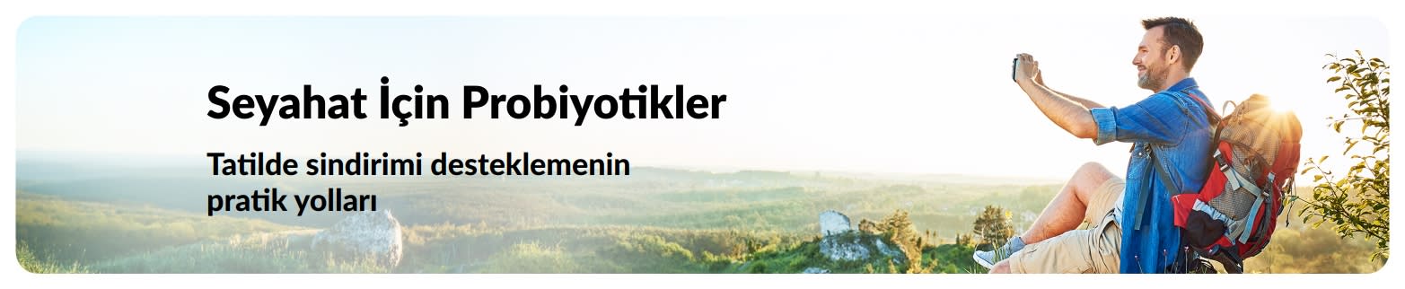 Seyahat probiyotikleri makalesi için, açık havada fotoğraf çeken sırt çantalı bir gezgini gösteren ve sağlıklı seyahat için probiyotiklerin önemini vurgulayan banner.