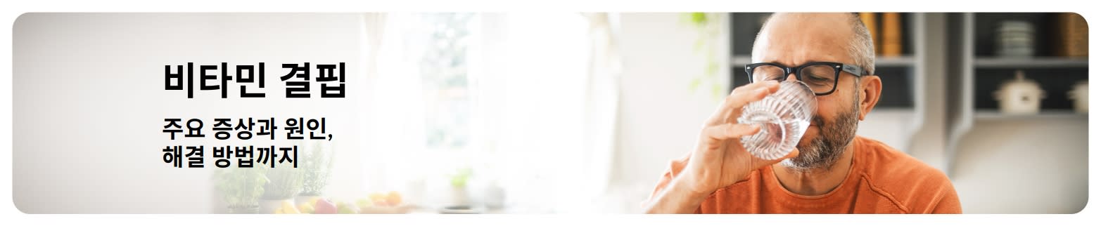 비타민 결핍 블로그 배너로, 증상과 원인에 대한 텍스트와 집에서 물을 마시는 남성이 포함된 이미지