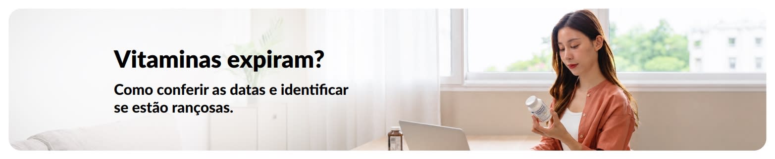 Mulher verificando um frasco de vitaminas em casa ao lado de um laptop com o texto: 