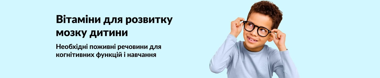 Усміхнена дитина в окулярах поруч із текстом, що рекламує вітаміни для дітей, які сприяють розвитку мозку, росту та навчанню.