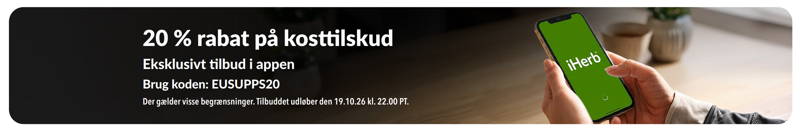 Hænder, der holder en telefon med iHerb-appen, hvor der reklameres for 20 % rabat på kosttilskud med koden EUSUPPS20.