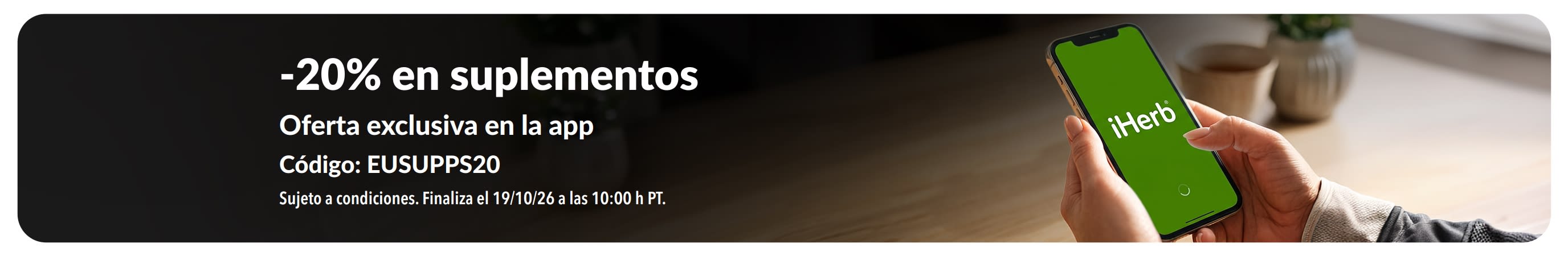 Manos sujetando un móvil con la aplicación de iHerb, donde se promociona un -20% en suplementos con el código EUSUPPS20.