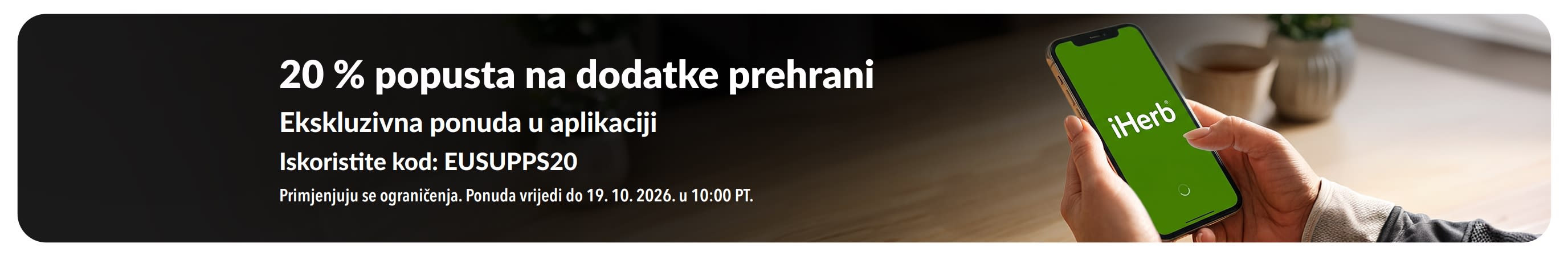 Reklamni natpis za promociju 20 % popusta na dodatke prehrani uz kod EUSUPPS20 s prikazom ruku koje drže mobitel s otvorenom aplikacijom iHerb.