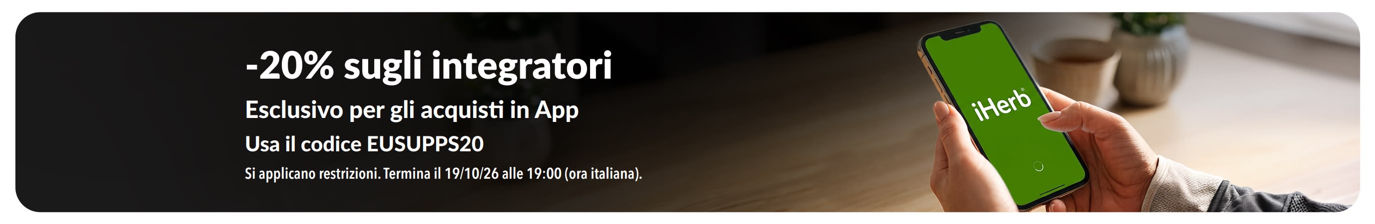 Mani che reggono un telefono con l'App iHerb; viene mostrata la promozione col 20% di sconto sugli integratori con il codice EUSUPPS20.
