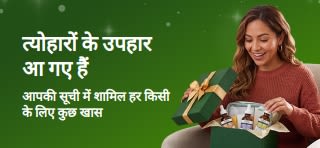 त्योहारों के उपहारों का बैनर, जिसमें एक मुस्कुराती हुई महिला स्किनकेयर सीरम से भरा हरा उपहार का डिब्बा खोल रही है।बैनर पर लिखा है: “त्योहारों के उपहार — आपकी सूची में हर किसी के लिए कुछ खास।”