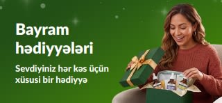 Dəri qulluğu serumları ilə dolu yaşıl hədiyyə qutusunu açan təbəssümlü qadının əks olunduğu 