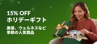 ホリデーギフトが15%OFFになるプロモーションバナー。美容やウェルネス、スキンケア商品が詰まったギフトボックスを開封する女性の画像。
