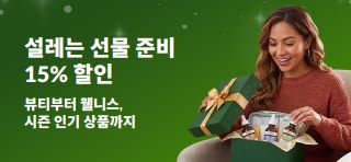 여성이 뷰티·웰니스 스킨케어 상품이 담긴 선물 상자를 여는 모습의 홀리데이 선물 15% 할인 프로모션 배너.