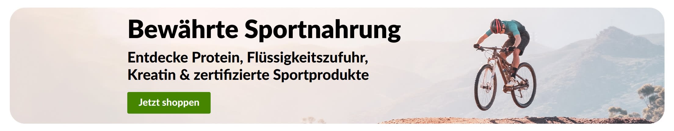 „Bewährte Sportnahrung“-Banner mit einem Mountainbiker und einem „Jetzt shoppen“-Button für Protein, Flüssigkeitszufuhr, Kreatin und sportzertifizierte Produkte.