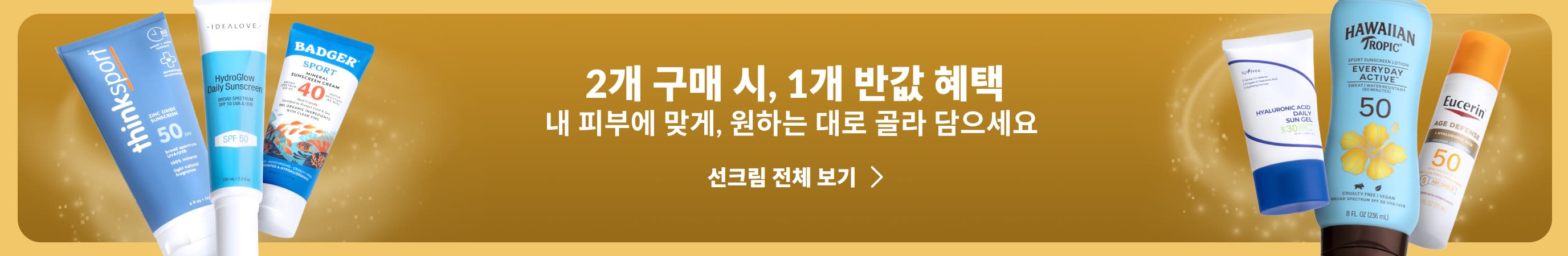 금색 배너 양옆에 다양한 선케어 제품이 배치되어 있으며, 배너에는 “선케어 필수품 1+1, 두 번째 제품 50% 할인”이라는 프로모션 문구가 표시됩니다.